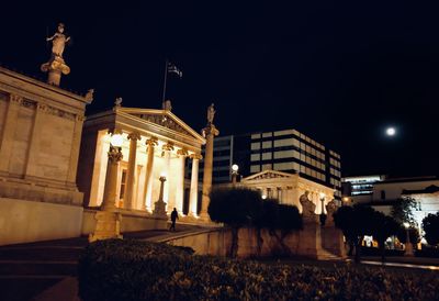 Statue in city at night