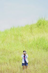 Woman photographing while standing by pants