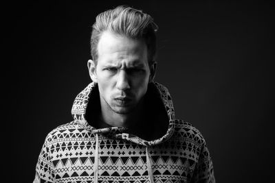 Portrait of man against black background