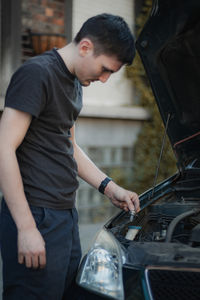 A young man holds a burnt out headlight bulb.
