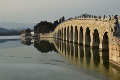 Arch bridge over river against clear sky