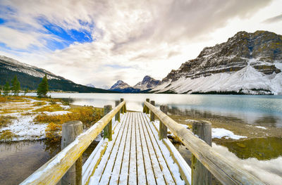 Scenic view of lake by mountains against sky