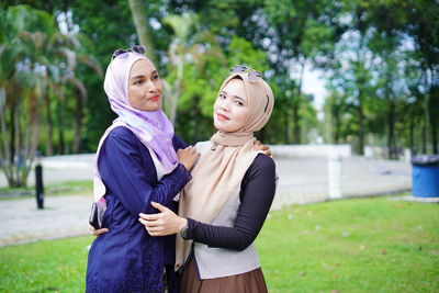 Woman with arms raised standing on field