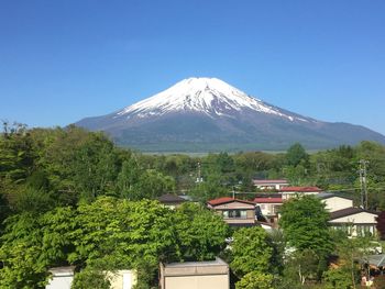 Scenic view of trees and mountains against clear blue sky