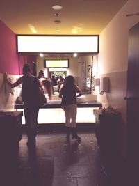 Women standing in illuminated room