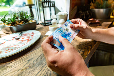 Close-up of hands holding food at restaurant