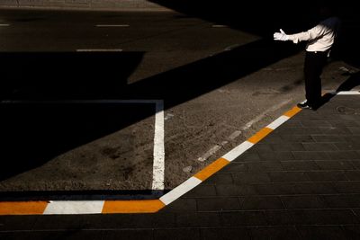 Low section of man standing on road