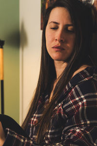 Portrait of young woman looking away at home