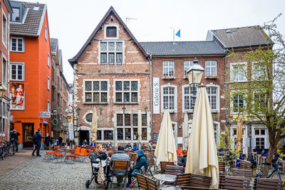 People sitting at outdoor restaurant against buildings