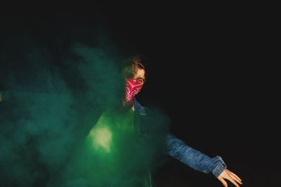 Portrait of man amidst smoke at night
