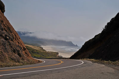 Road amidst mountains against sky