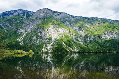 Scenic view of lake by mountains against sky