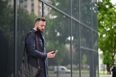Full length of young man using mobile phone