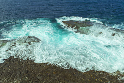 High angle view of surf on shore at beach