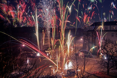 Firework display over illuminated city at night