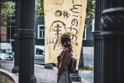 Full length rear view of woman standing in city