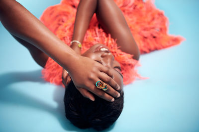 Young woman looking away against blue background