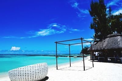 Swimming pool on beach against blue sky