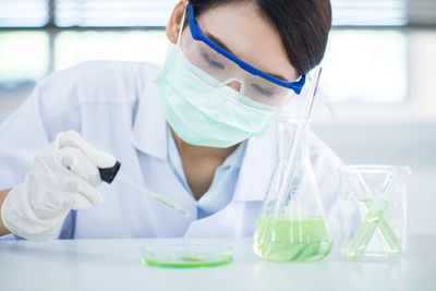 Close-up of female scientist experimenting in laboratory