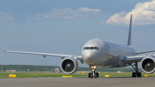 Airplane on runway against sky