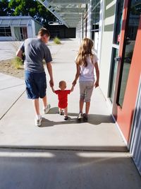 Rear view of people walking on floor