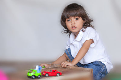 Portrait of cute girl sitting with toy