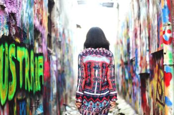 Rear view of woman walking amidst graffiti