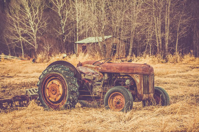Close-up of tractor on field against trees
