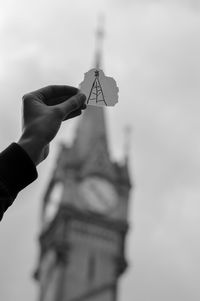 Cropped hand holding drawing in front of haymarket memorial clock tower