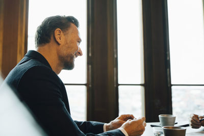 Smiling male entrepreneur in discussion with colleague in office