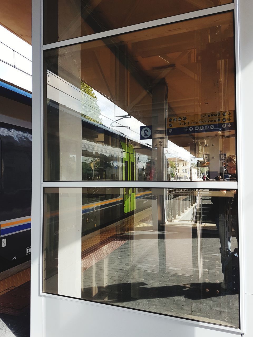 REFLECTION OF TRAIN ON GLASS WINDOW OF RAILROAD STATION