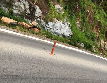 Road sign on rock by street