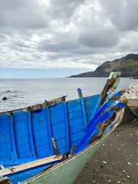 Boats moored on beach against sky