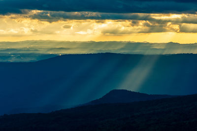 Scenic view of landscape against dramatic sky during sunset