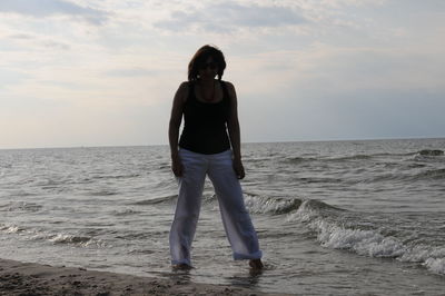 Woman standing on shore against sea at beach