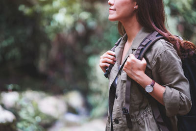 Midsection of woman standing against tree