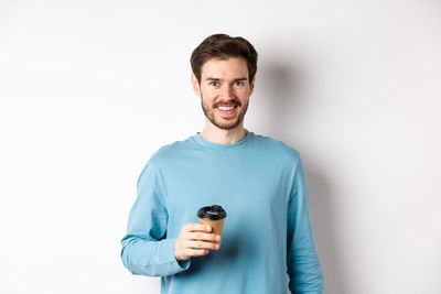 Portrait of smiling young man against white background