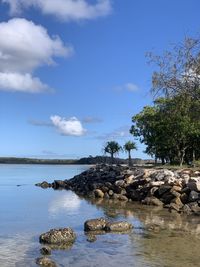 Rocks by sea against sky