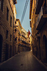 Low angle view of narrow alley amidst buildings in city