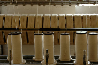 Close-up of thread spools on loom