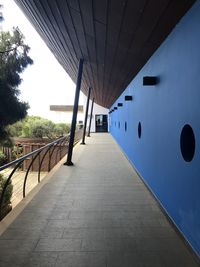 Empty footpath amidst buildings against sky