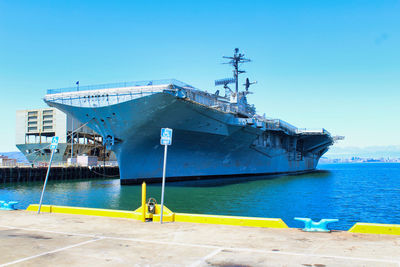 Ship moored in sea against clear blue sky