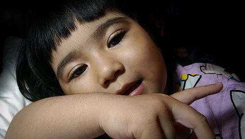 Close-up portrait of girl leaning on bed