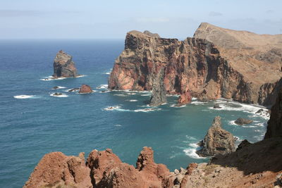 Scenic view of rocks in sea against sky