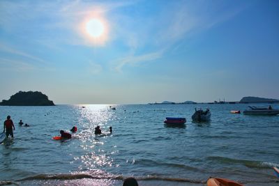 People enjoying in sea against sky