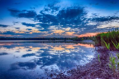 Scenic view of lake against sky at sunset