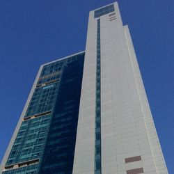 Low angle view of modern buildings against blue sky