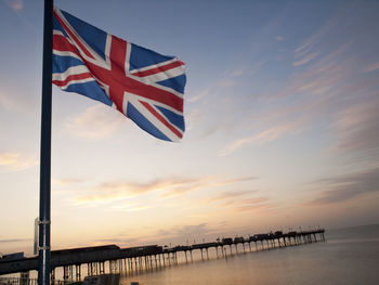 Scenic view of flag against sky during sunset