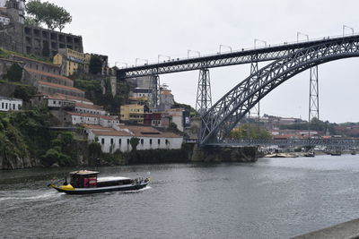 Bridge over river in city against sky