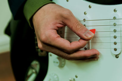 Midsection of man playing guitar